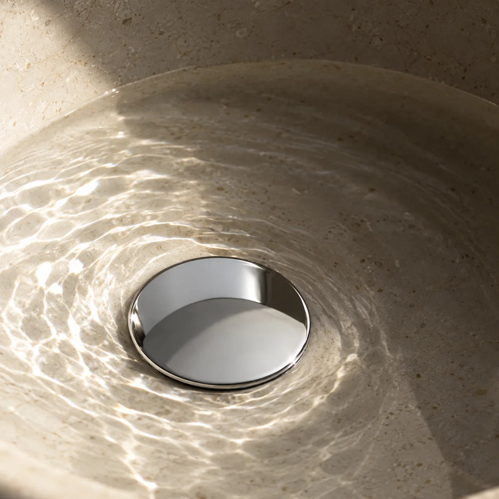 Bonde de Lavabo Clic-Clac en chrome, installée au fond d’une vasque en pierre