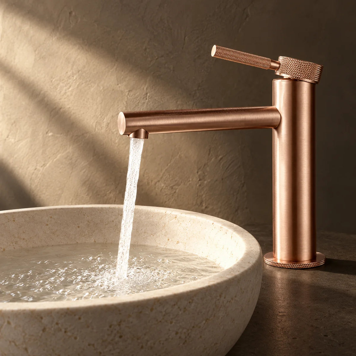 Mitigeur Lavabo Poignée Moletée, Bec Intermédiaire en or rose brossé, installé sur un plan de salle de bain